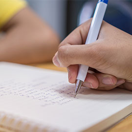 Student writes on notebook while learning study 