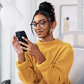 Office, Indian woman in glasses with smartphone for reading. Smile, businessperson on break with mobile, news application and chat on social media.