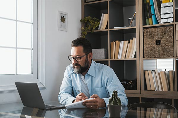 Bearded man looking at laptop