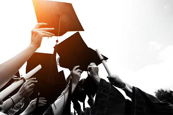 Graduation caps and diplomas, hands celebrating