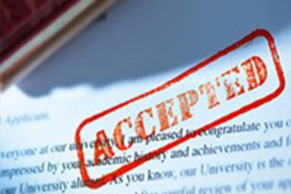 College application with accepted stamp on a desk