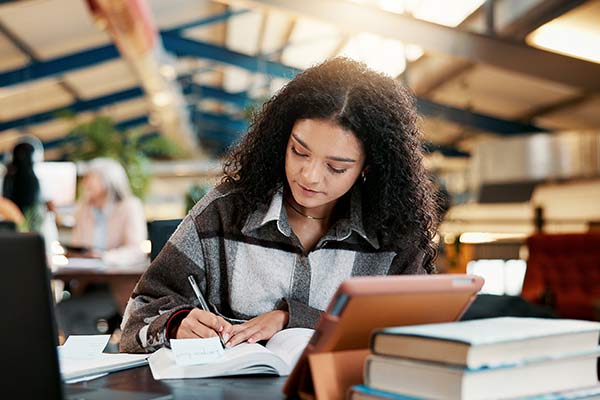 Female tudent taking notes in a library