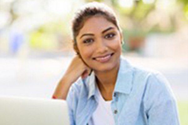 Young adult female using a laptop outside