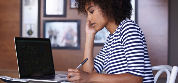 Woman at Computer learning about various types of financial aid available